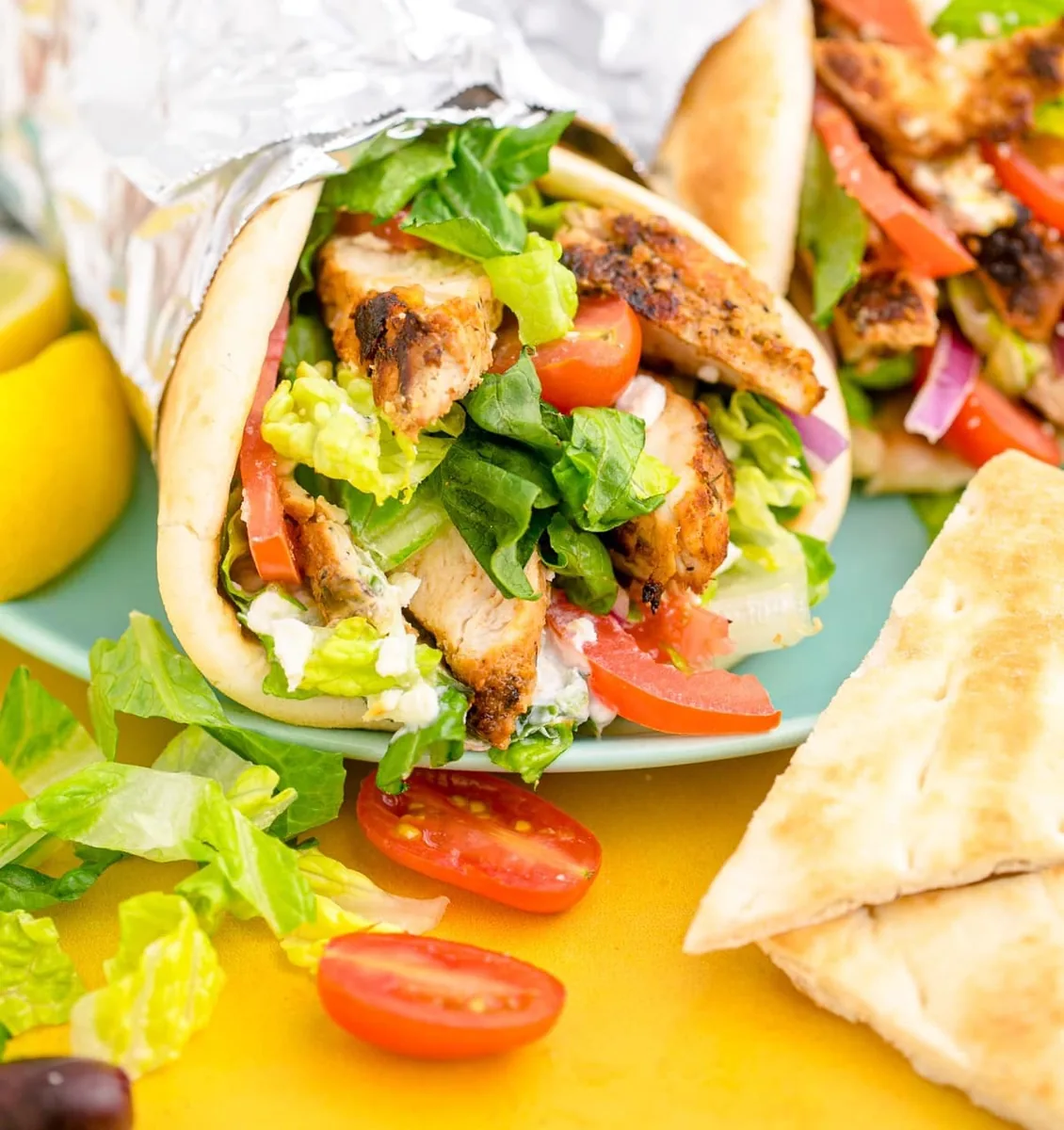 Chicken gyro in grilled pita with vegetables and white sauce