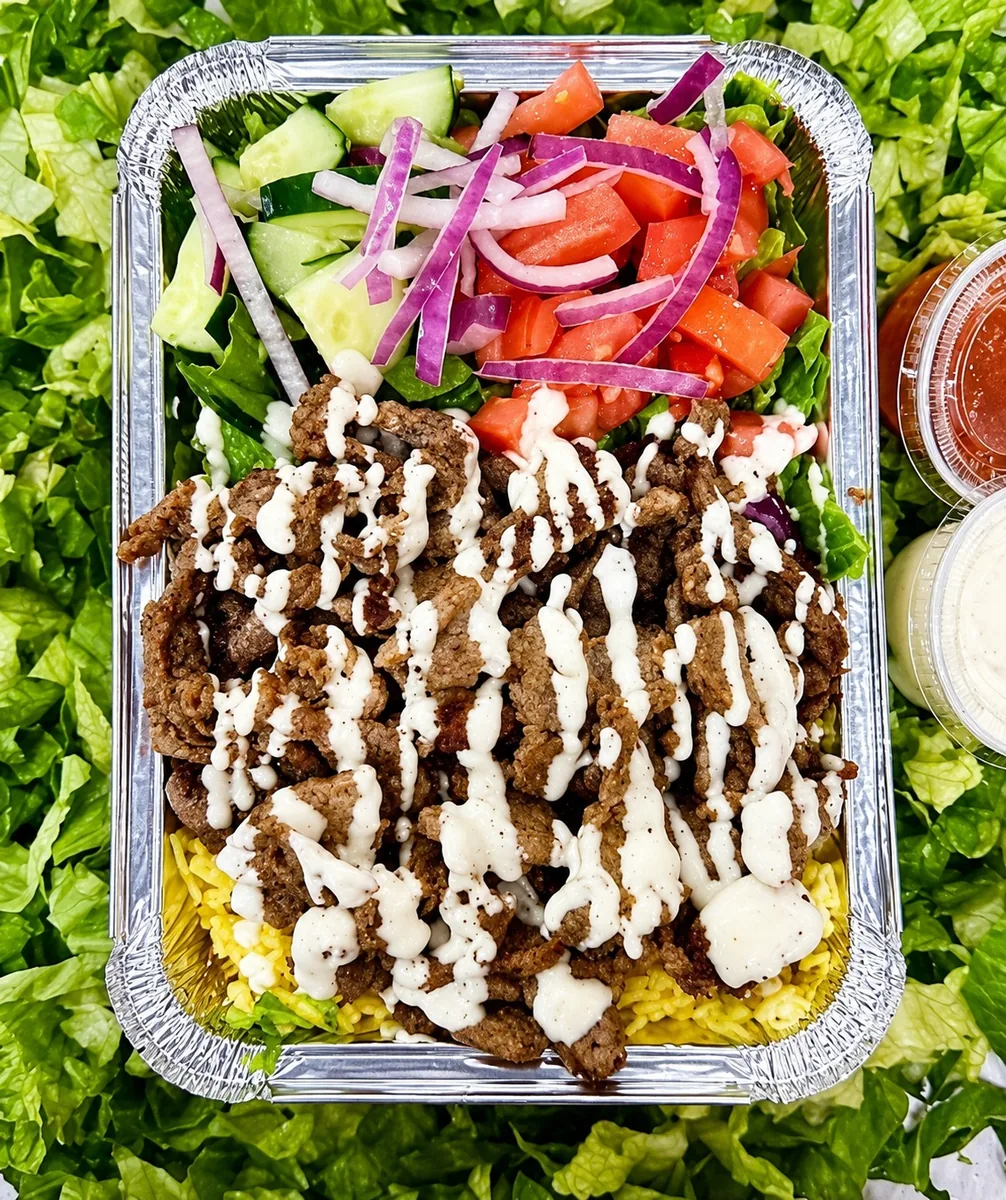 Lamb over rice with salad and white sauce