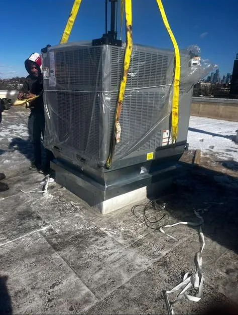 Commercial rooftop HVAC unit crane lift with city skyline